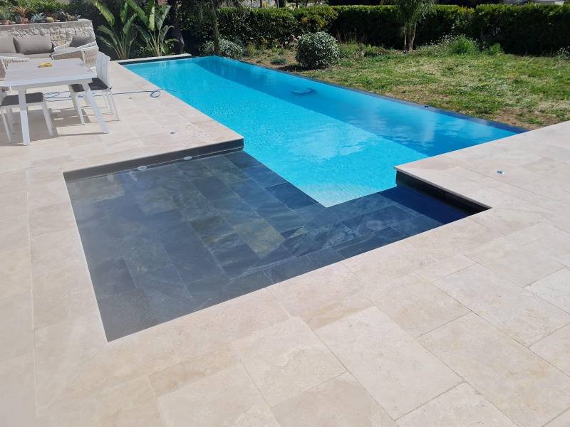 Réalisation d'une piscine haut de gamme à débordement avec une plage immergée en pierre de Bali à Biot Alpes Maritimes ou ailleurs